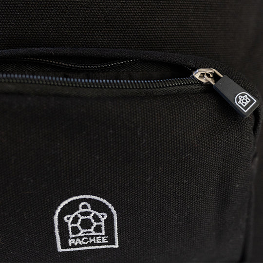 Black canvas backpack with a front small compartment zip open, featuring the Pachee logo on the zip and backpack. Available at Pachee.