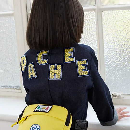 Girl wearing a jacket with alphabet patches spelling "Pachee", showcasing stylish letteers.