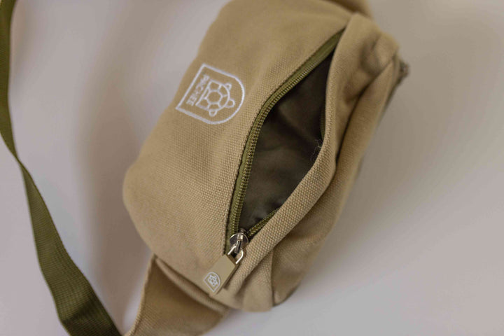 Close-up of a brown bum bag from Pachee, showcasing the front compartment opened to reveal its spacious interior.