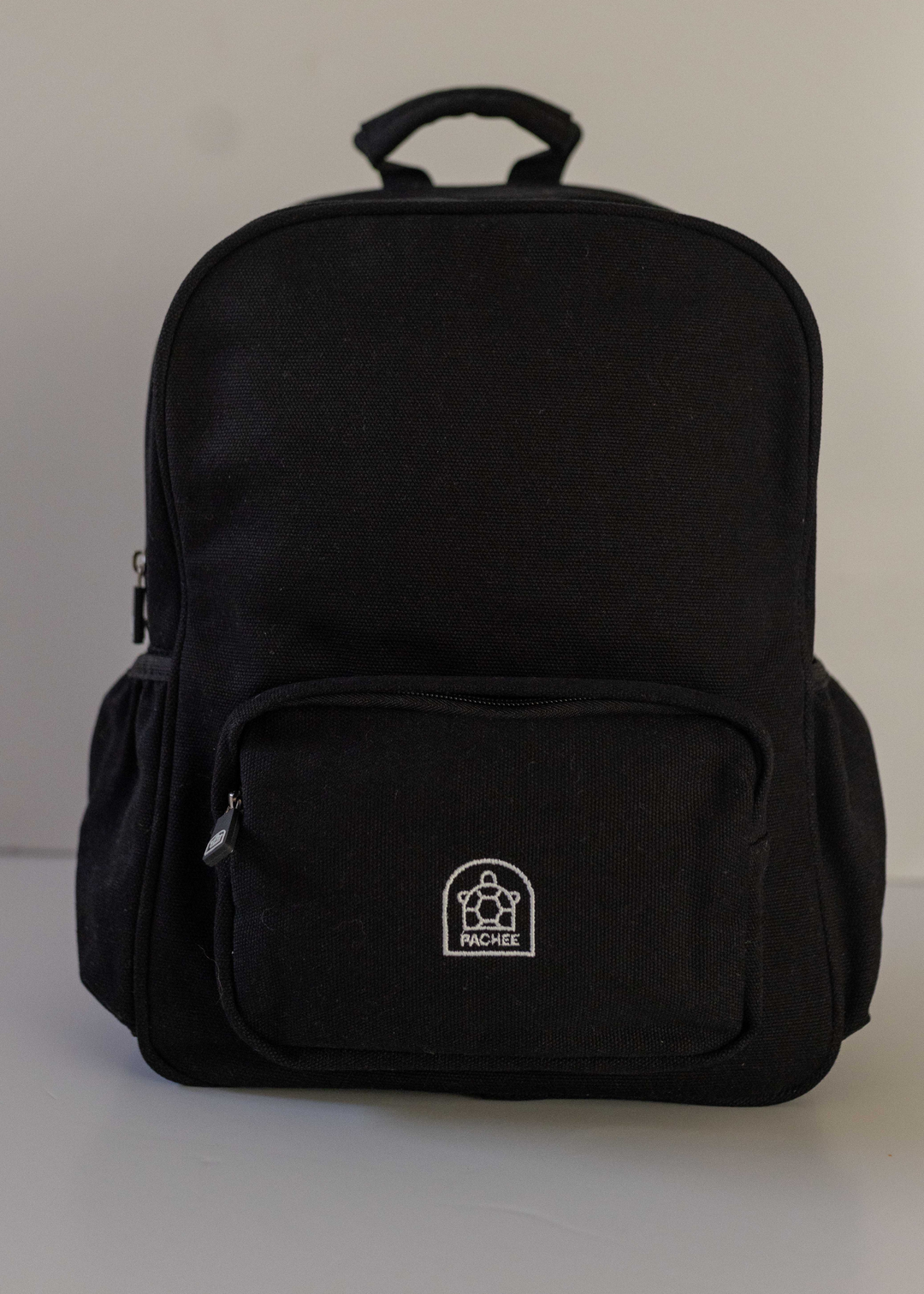 Canvas Black Junior backpack with Pachee logo displayed on the front, featuring a sleek design, available at Pachee online store.
