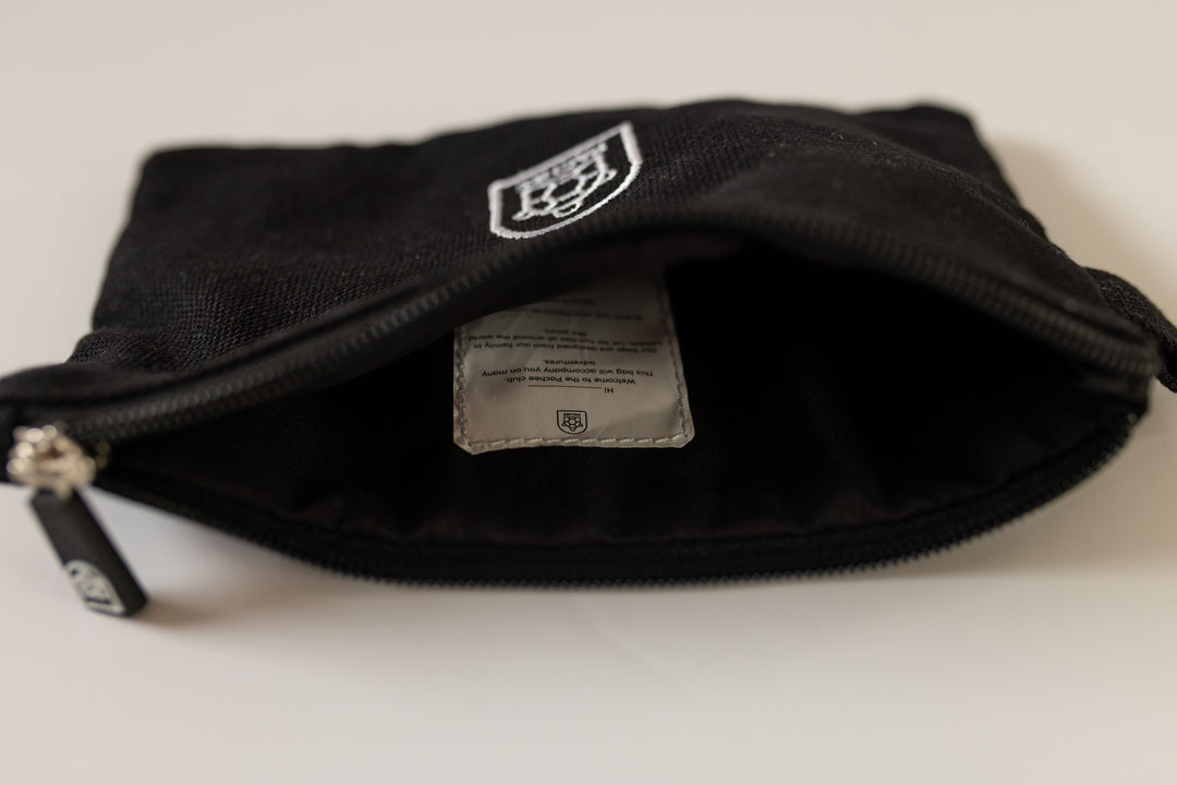 A black canvas zipper pouch opened, showcasing its spacious interior, available at Pachee's online store in the UK.