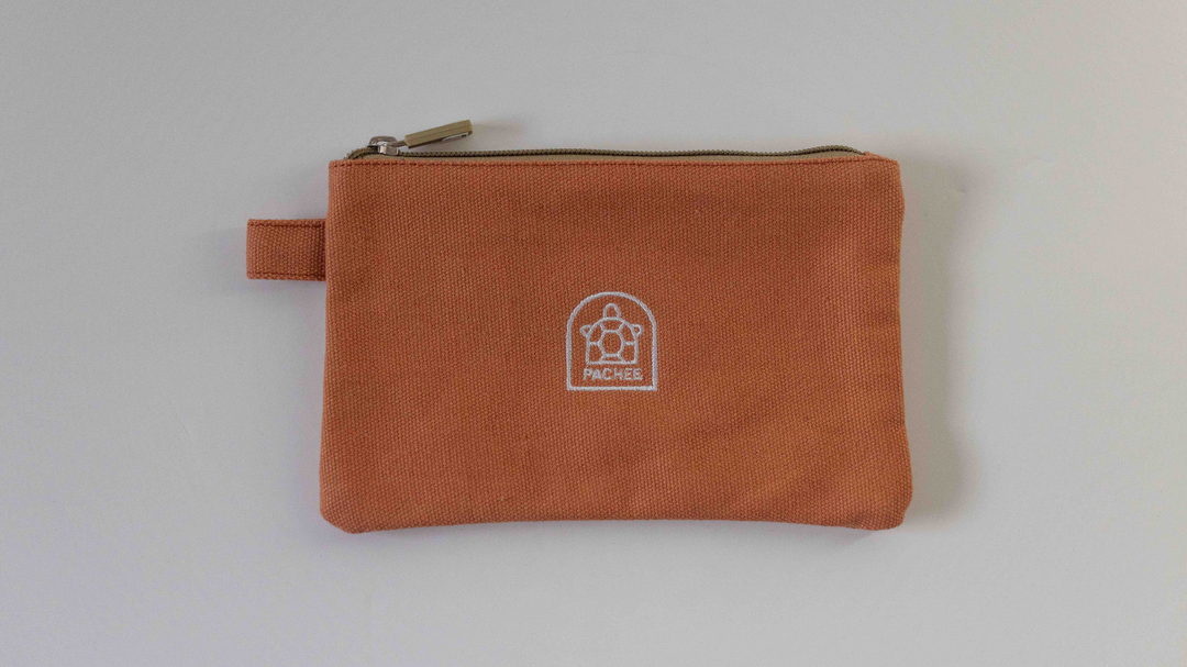 Cotton orange pouch with a closed zip and side holder, perfect for everyday use. Available at Pachee online store in the UK.