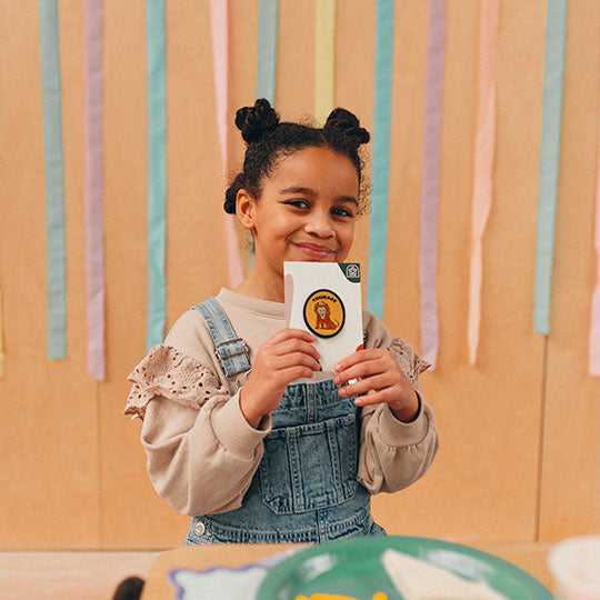 A girl proudly displaying a "Lion - Courage" patch, symbolising strength and bravery.