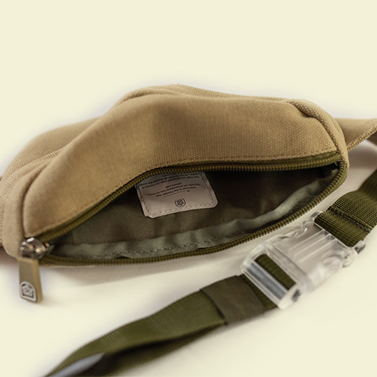 Neutral-colored crossbody kids bum bag showcasing spacious interior with Pachee welcome tag, lengthy strap and transparent buckle. 