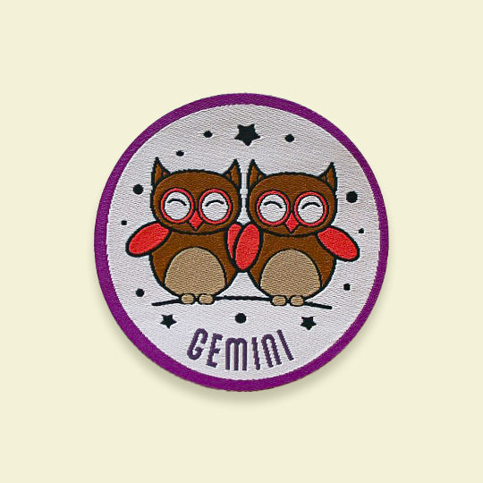 Gemini iron-on patch featuring vibrant twin symbols with the text 'Gemini' displayed prominently, ideal for personalization.