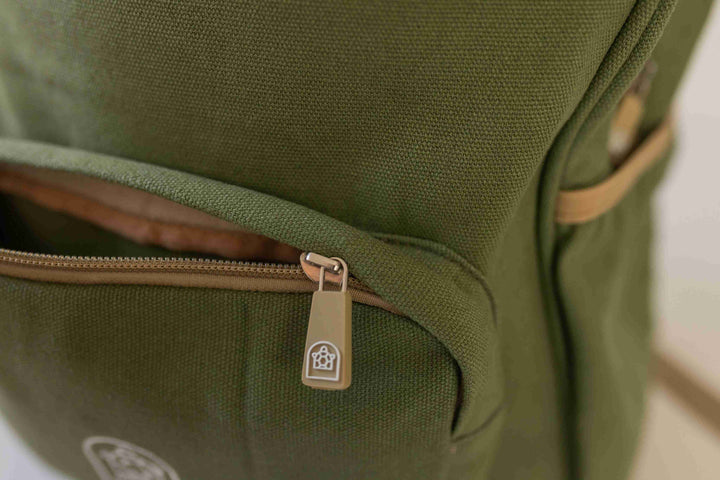 Junior backpack in sage green color with a small compartment opened, showcasing its practical design. Available at Pachee.