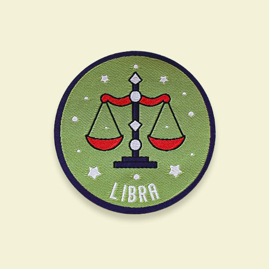 Libra iron-on patch featuring the Libra zodiac symbol and the text 'Libra,' perfect for customizing clothing or accessories.
