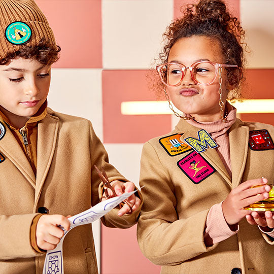 Children wearing jackets and hats with personalised colourful patches, adding a fun and unique touch to their outfits.