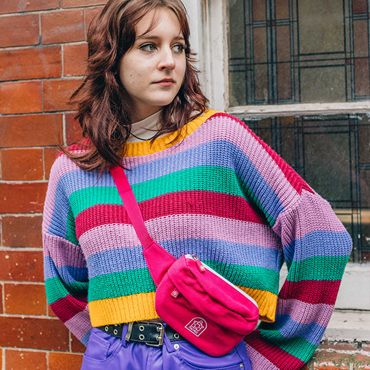 A girl wearing a pink crossbody bumbag, stylish and practical for everyday use, complementing her casual outfit.