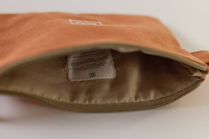 Small orange pouch displayed open, showcasing its vibrant interior, available for purchase from Pachee's online store in the UK.