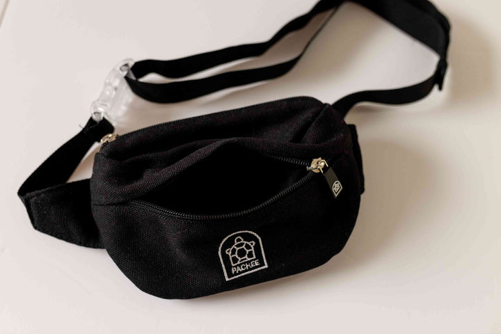 Image of a trendy black bum bag with the front compartment open, revealing spacious storage and a fully extended adjustable strap.