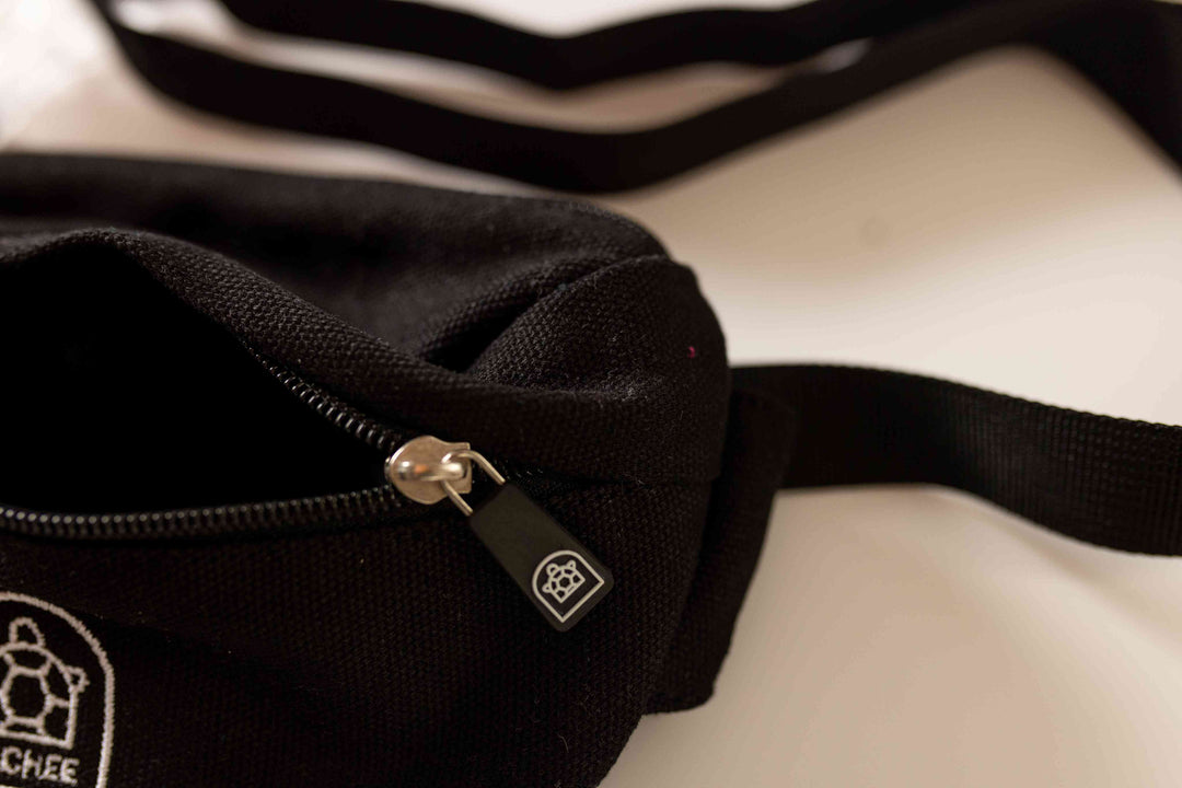 A sleek black zipper bum bag with a stylish front zip design, showcasing a modern and minimalist aesthetic for fashion-forward looks.